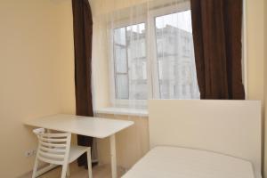 a white table and chair in a room with a window at Vytauto av 9 - Kaunas Students Home LT in Kaunas