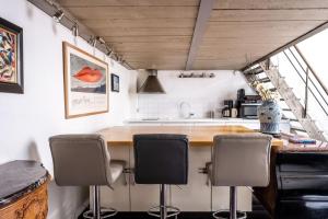 a kitchen with a counter with chairs and a sink at Veeve - Heart of Saint Germain in Paris