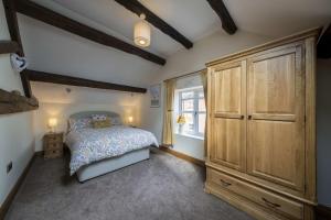 GoostreyにあるThe Hoglets 2のベッドルーム1室(ベッド1台付)、大きな木製キャビネットが備わります。