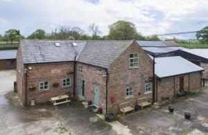 an old brick building with solar panels on it at The Hoglets 2 in Goostrey