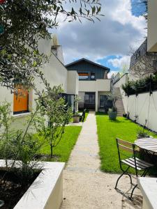 a garden with a bench and a house at Villa Victorine in Nogent-sur-Marne