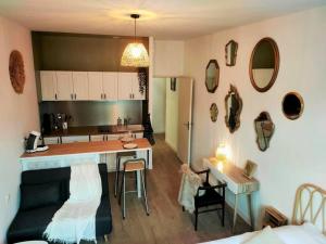 a kitchen and a living room with a counter and a table at Agréable studio du Coderc avec balnéo in Périgueux