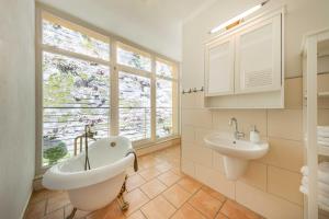 łazienka z wanną, umywalką i oknem w obiekcie Villa Emma, Wellness & Ayurveda w mieście Bad Schandau