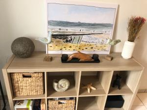a wooden cabinet with a picture of the beach at Le tennis garden in Villers-sur-Mer