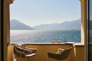 einen Balkon mit Blick auf das Wasser und die Berge in der Unterkunft Vista Lakefront Boutique Hotel in Ascona