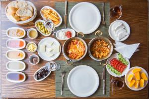 una mesa de madera con platos de comida. en PALMYRA BOUTIQUE HOTEL, en Sanlıurfa