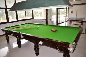 a pool table in a room with a green cloth at Sunshine Beach Condotel by Lux in Na Jomtien