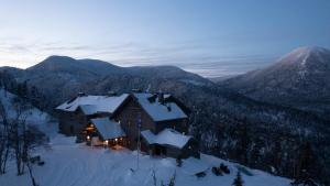 una grande casa nella neve in montagna di Auberge de Montagne des Chic-Chocs Mountain Lodge - Sepaq a Sainte-Anne-des-Monts
