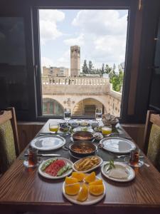 PALMYRA BOUTIQUE HOTEL في سانليورفا: طاولة مليئة بالطعام مطلة على مبنى
