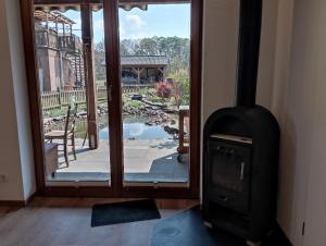 a wood stove in a room with a view of a patio at Gepetto Ferienhaus Wissenbach in Hademstorf