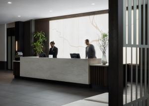 two people standing at a reception desk at AC Hotel by Marriott Dayton in Dayton