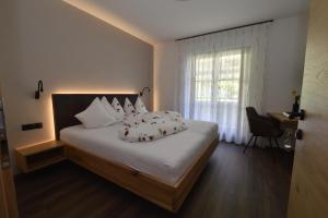 Appartements Lenzenhof في بارشينيس: غرفة نوم بسرير وملاءات بيضاء ونافذة