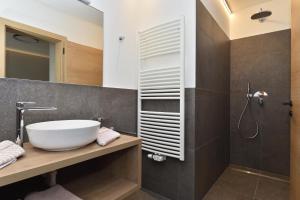 Appartements Lenzenhof في بارشينيس: حمام مع حوض أبيض ودش