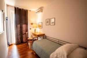 une chambre avec un lit, une table et une fenêtre dans l'établissement Eco di Mare - Apartment, à Polignano a Mare