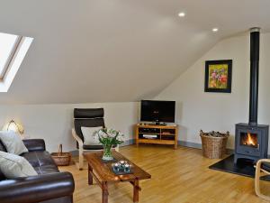 a living room with a couch and a fireplace at Field View in Cynghordy