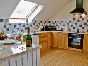 a kitchen with a bottle of wine and glasses on a counter at Field View in Cynghordy