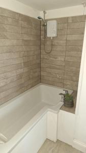 a bathroom with a bath tub with a shower at Osprey Meadow Holiday Cottages in Bedale