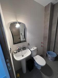 a bathroom with a sink and a toilet and a mirror at Appartement Irena neuf à 5 min de la plage in Saïdia