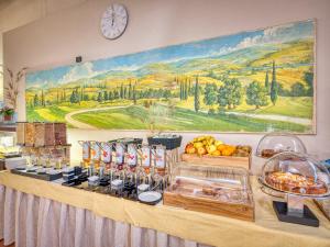 un buffet con cibo e un orologio sul muro di Active Hotel Paradiso & Golf a Peschiera del Garda