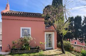 une maison rose avec un arbre dans la cour dans l'établissement Chambre d'hôtes en duplex du petit mas niçois, à Nice