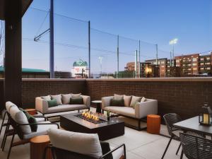 a rooftop patio with couches and tables and chairs at AC Hotel by Marriott Dayton in Dayton