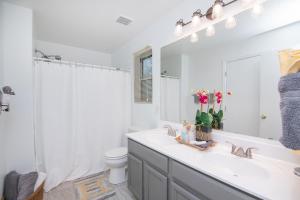 La salle de bains est pourvue d'un lavabo, de toilettes et d'un miroir. dans l'établissement Stylish Home Phoenix - Low Rates NOW!, à Phoenix