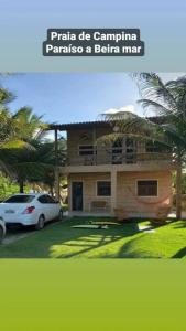 a house with a car parked in front of it at casa de praia a beira mar in Campina