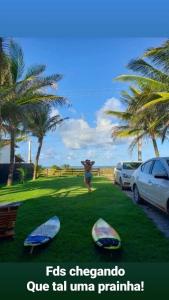 a woman standing on a lawn with palm trees at casa de praia a beira mar in Campina