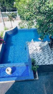 ブンタウにあるThe Lux Villa Pool - Tran Phuの青いタイルと椅子が備わるスイミングプール