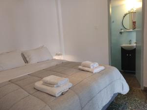 a bedroom with a large bed with towels on it at Grandma's sifnos house in Platis Gialos