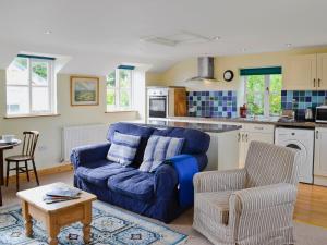 a living room with a blue couch and a kitchen at Tucked Away in Linkinhorne
