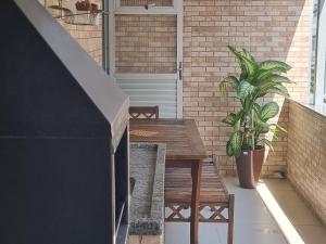 a patio with a table and a potted plant at Apartamento Vila Aconchego Vermelho in Salvador