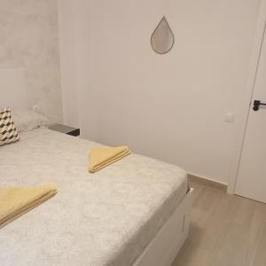 a white bedroom with a bed with a white wall at Sweet dreams in Alicante
