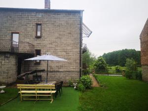 een patio met een tafel en een parasol bij Wsi spokojna...Jura in Siamoszyce
