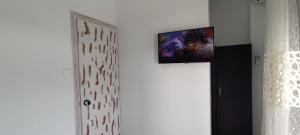 a flat screen tv on a wall next to a door at Wave Sound Apartments - Beach View in Skala Marion