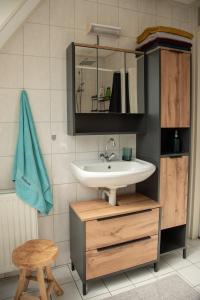 a bathroom with a sink and a mirror and a stool at Heerlijk genieten. in Hoogersmilde