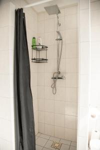 a shower with a black shower curtain in a bathroom at Heerlijk genieten. in Hoogersmilde