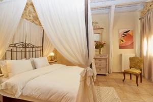 a bedroom with a canopy bed and a chair at Villa Arhontiko In Arhanes in Archanes