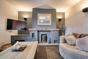 a living room with a couch and a fireplace at Guest Homes - Birches Barn in Wolverhampton