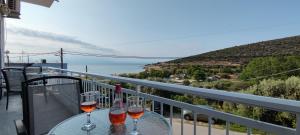 two glasses of wine sitting on a table on a balcony at Wave Sound Apartments - Beach View in Skala Marion