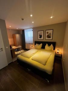 a bedroom with a large bed with yellow sheets and pillows at mala me Hotel in Hannover