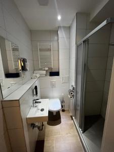 a bathroom with a toilet and a sink and a shower at mala me Hotel in Hannover +55 photos