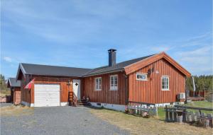a large wooden barn with a white garage at Awesome Home In Leira I Valdres With Kitchen in Leira
