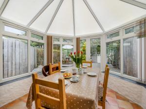 a dining room with a table and chairs and windows at Little Springfield in Hayle