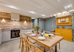 a kitchen and dining room with a wooden table and chairs at The Barn at The Foldyard in Holme upon Spalding Moor