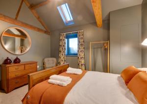 a bedroom with a bed with two towels on it at The Barn at The Foldyard in Holme upon Spalding Moor