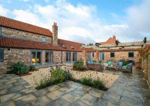 an exterior view of a brick house with a patio at The Barn at The Foldyard in Holme upon Spalding Moor