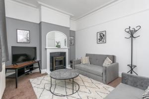 a living room with a couch and a fireplace at Victoria Parade in Rossendale