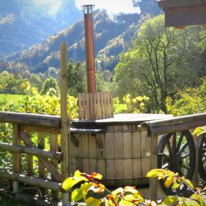 a wooden hot tub with a wooden fence and mountains at Chalet trappeur in Le Biot