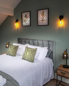 a bedroom with a white bed with three pictures on the wall at Victoria Parade in Rossendale